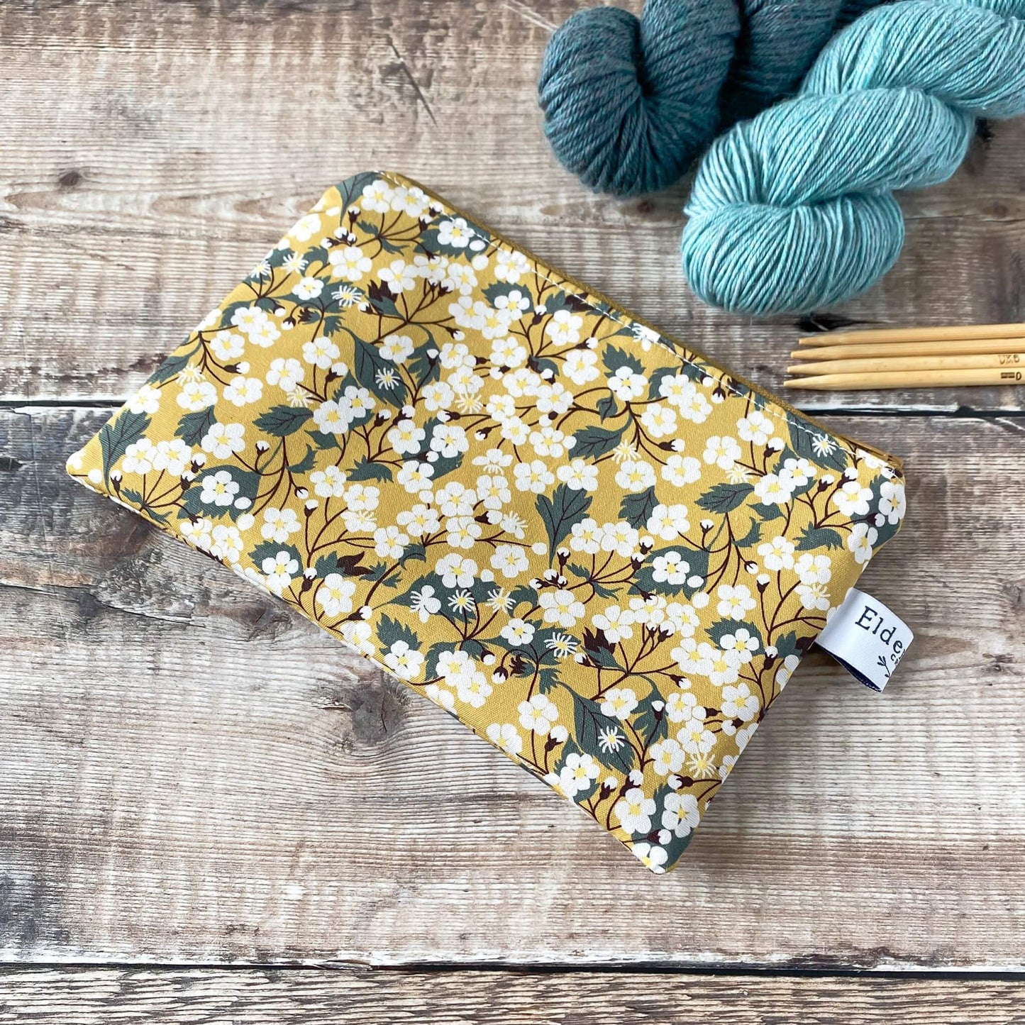 A yellow pouch made from yellow Liberty of London fabric, designed to be used as a storage pouch for notions.