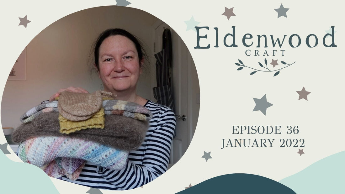 Emma who is the founder of Eldenwood Craft shows her current knitting projects on her podcast. She wears a blue striped top like she often does. 