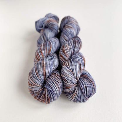 Yarn wound into two skeins. The yarn has been dyed with blue and brown dyes. 