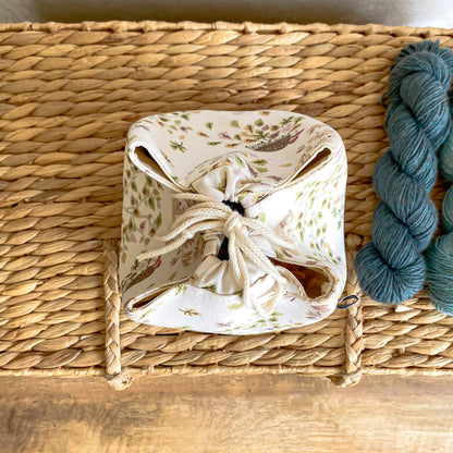 A top down view of a project bag pulled closed. The bag is based on the Japanese rice bag design and comes in two sizes - small for sock and hat projects, and medium for projects needing around 3 to 4 skeins of yarn. 