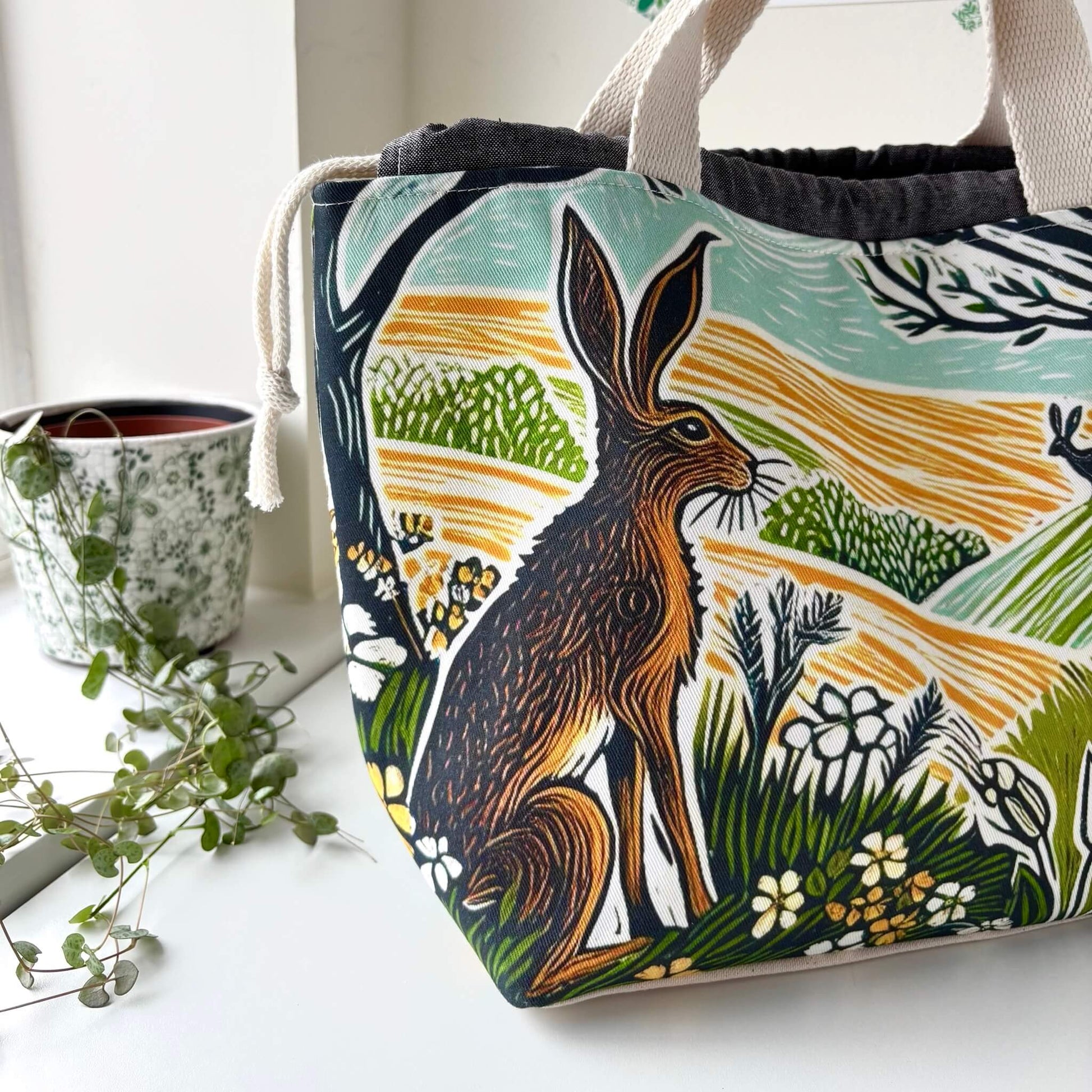 Fabric bag with a hare design sitting on a white surface
