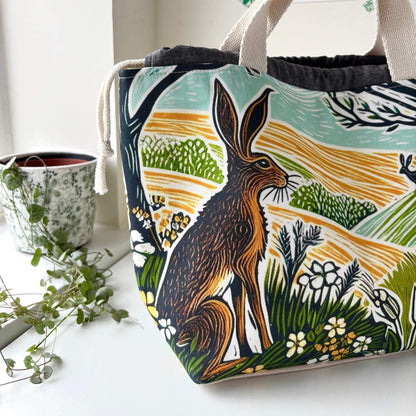 Fabric bag with a hare design sitting on a white surface