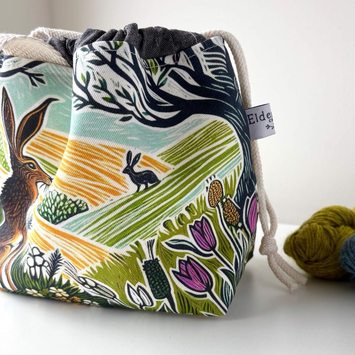 Fabric drawstring bag with nature-themed design on a white background