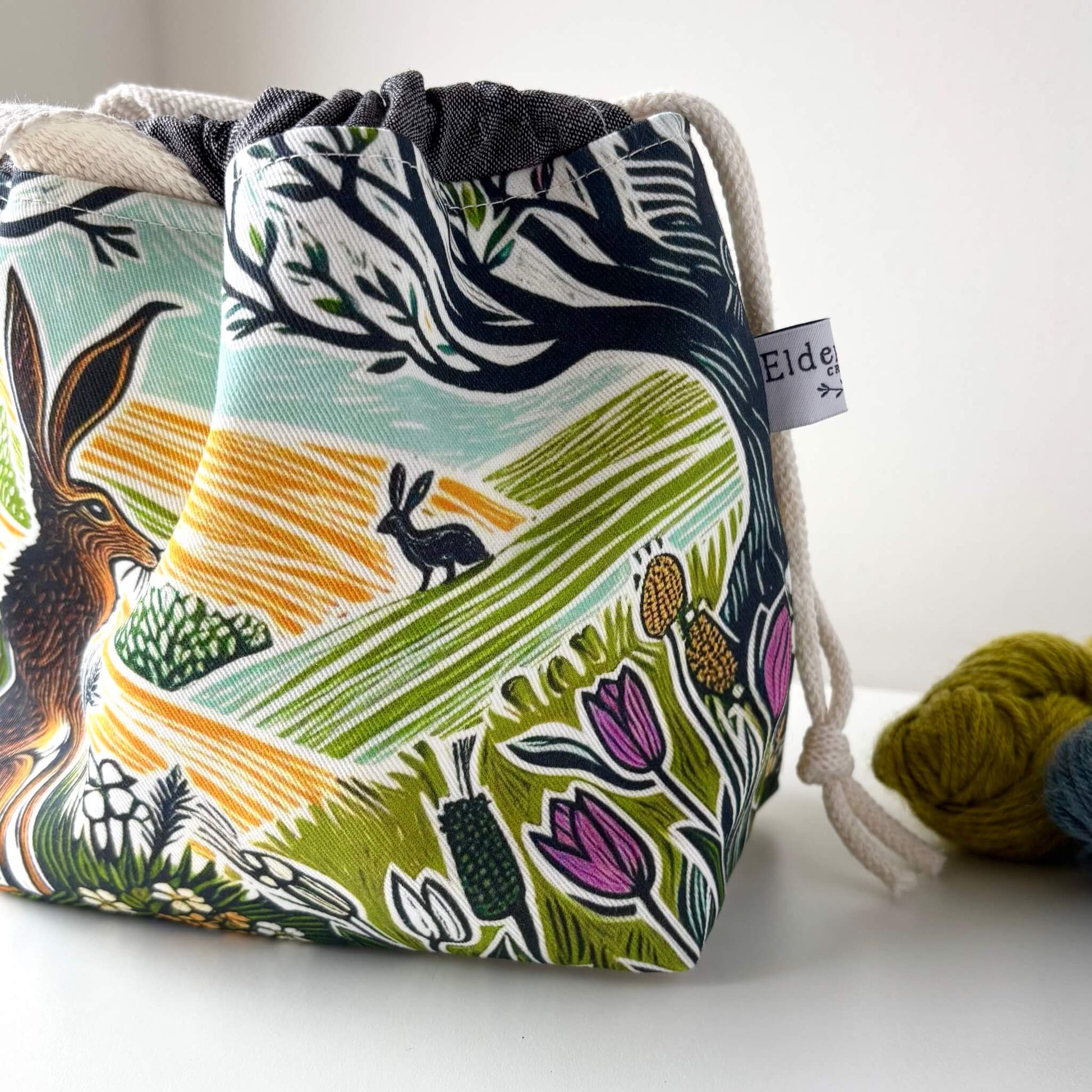 Fabric drawstring bag with nature-themed design on a white background