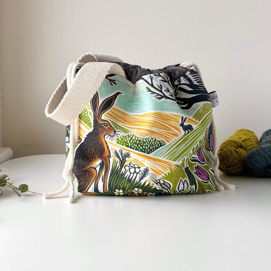Fabric drawstring bag with nature-themed design on a white surface
