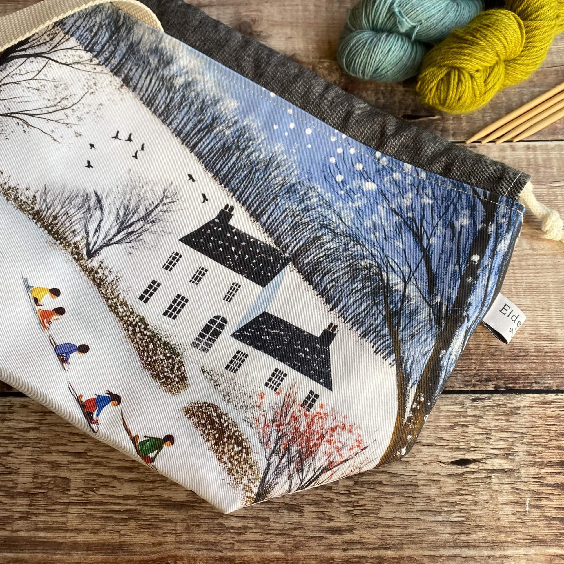 Winter project bag featuring a snowy country house print, handmade and structured for knitting and crochet storage.