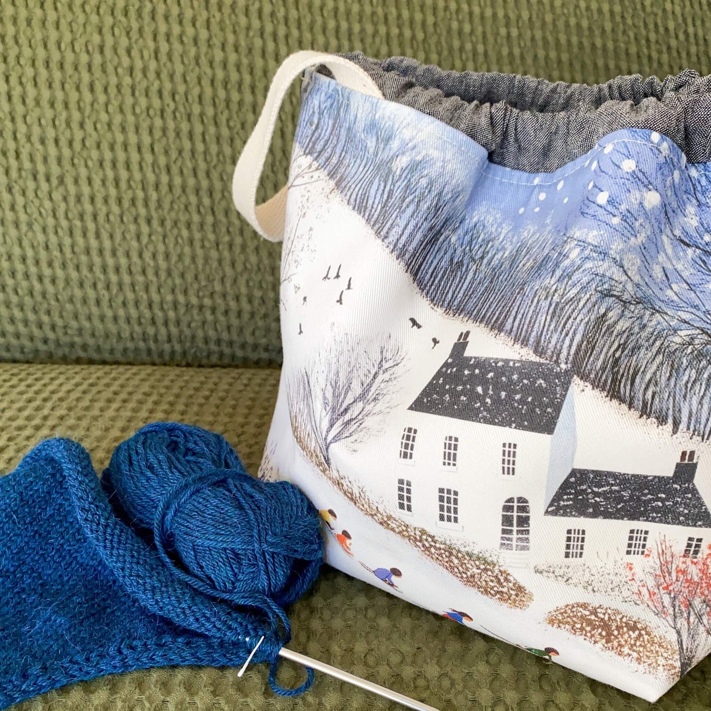 Winter knitting project bag with pockets, shown in a snowy countryside fabric
