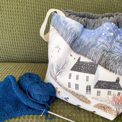 Winter knitting project bag with pockets, shown in a snowy countryside fabric