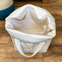 Load image into Gallery viewer, The empty inside of a knitting project bag is seen, showing lots of pockets for storage. 