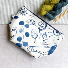 Load image into Gallery viewer,  A knitting project bag placed on a table. The bag is made of fabric with a folk art image printed in indigo color. It features various motifs like leaves, birds, and flowers.