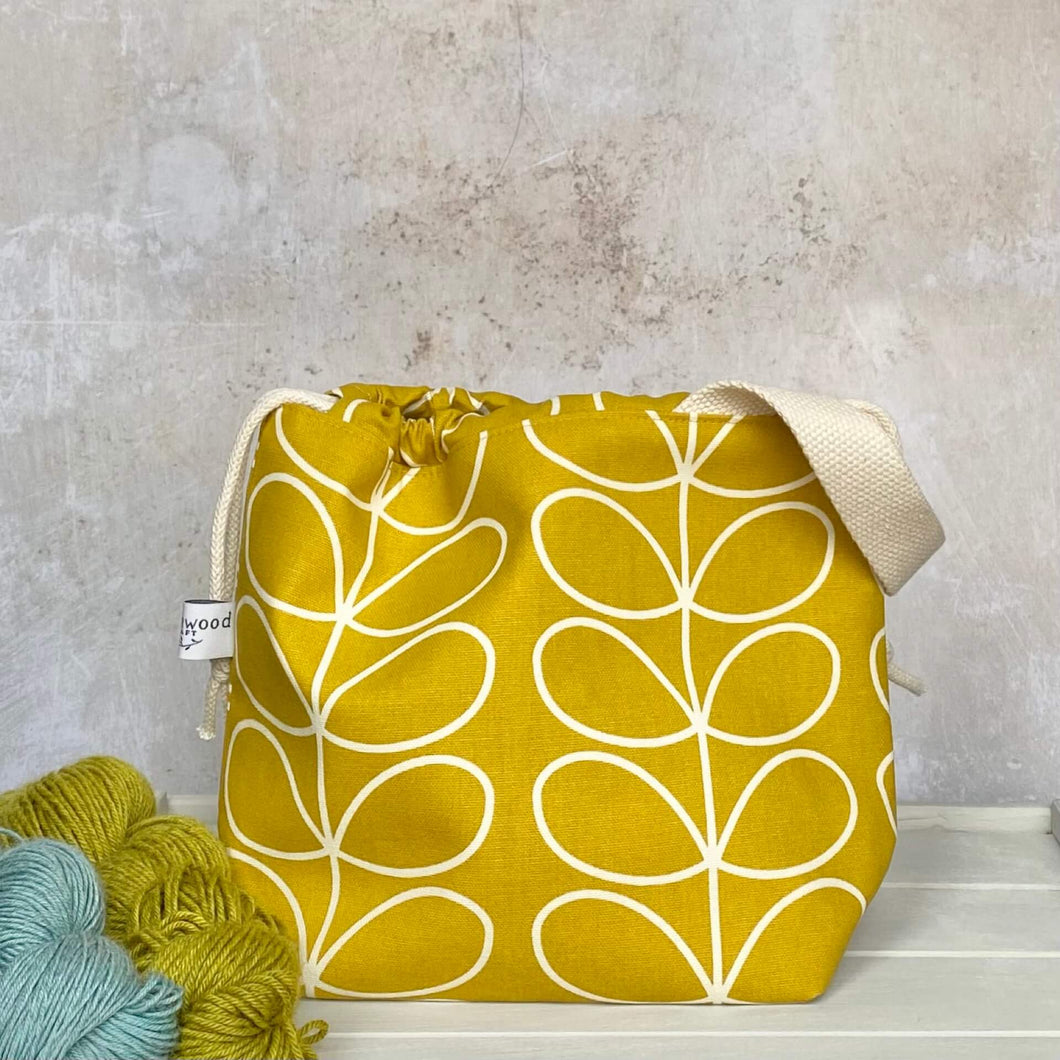 A knitting project bag in a beautiful sunshine yellow Orla Kiely fabric featuring the iconic linear stem print